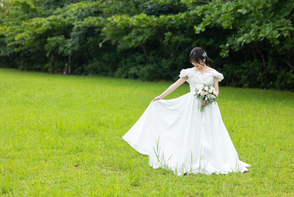 グリーンの芝生の上でホワイトドレスを着た新婦のソロショット