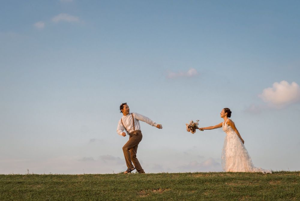 カップルが野原で追いかけあう