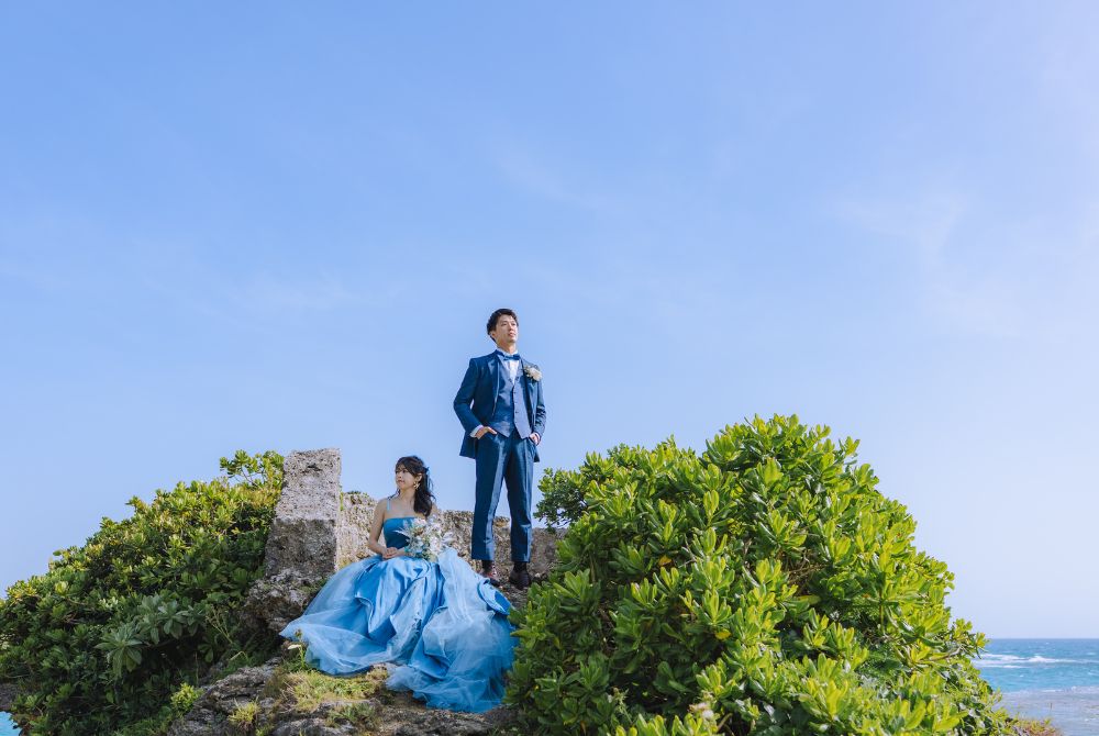 青い空をキャンバスにポーズをとるカップル