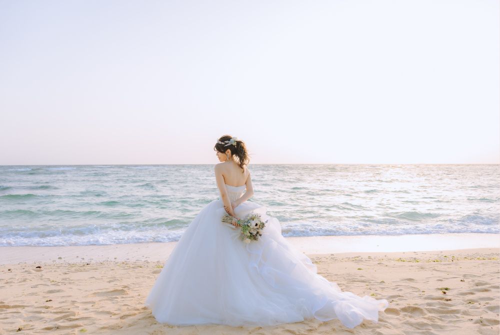 ホワイトドレスを着てビーチにたつ新婦のバックショット