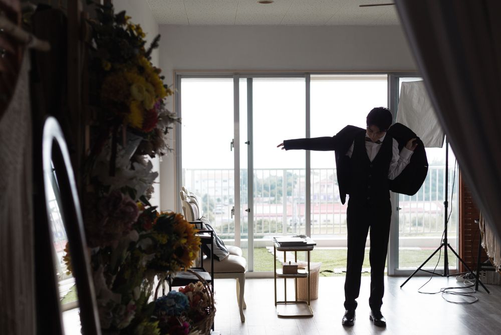 お仕度中でジャケットを着ようとしている新郎様